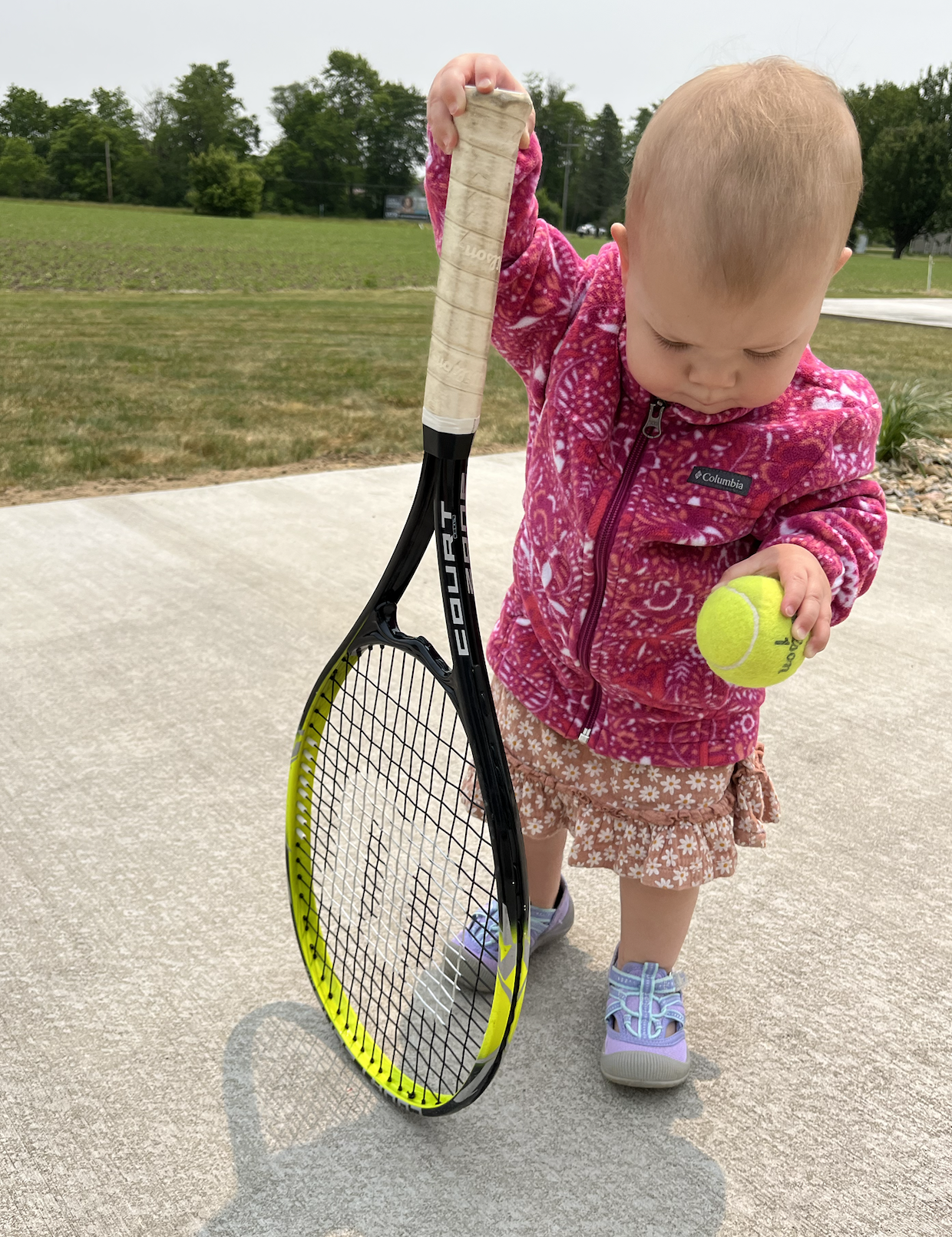 Baby girl with a tennis ball and a racket